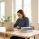 Junge Fachkraft lernt am modernen Schreibtisch mit Laptop und Büchern in hellem deutschem Büro mit Tageslicht.